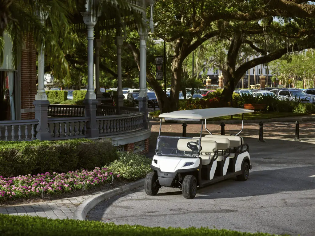 A Toro Vista Passenger Transport Vehicle  parked infront of a university campus building