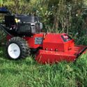 Toro BRC-28 self-propelled brush cutter mowing through overgrown vegetation on uneven ground