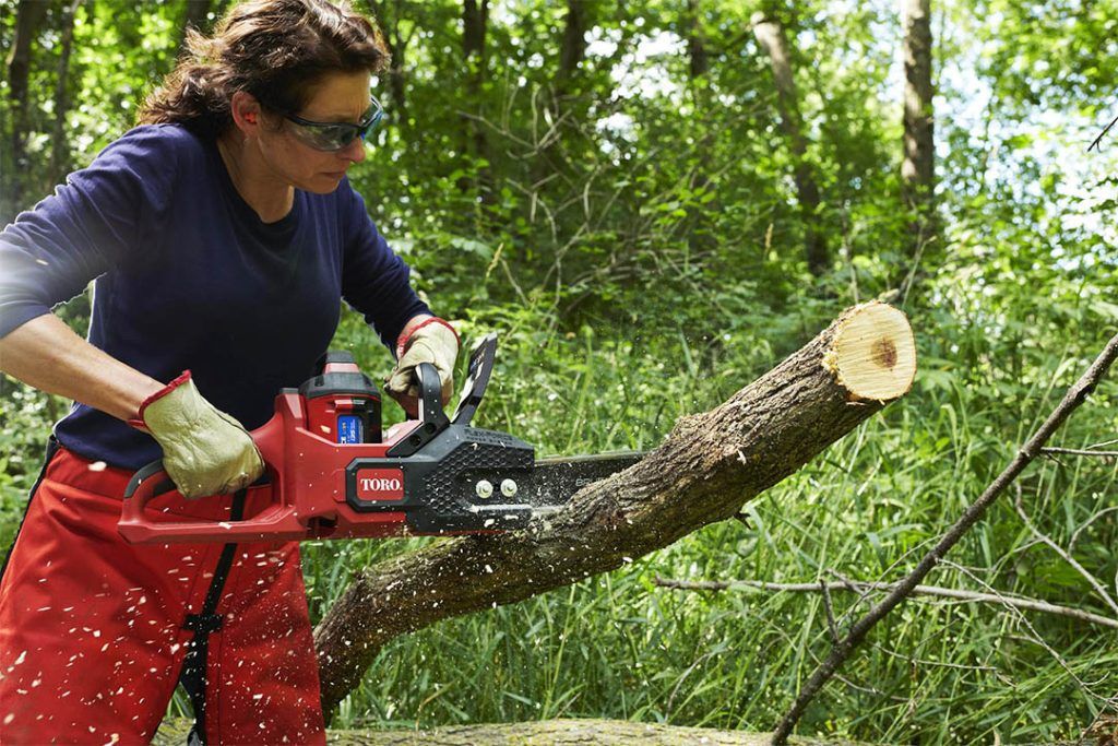 TORO Flex Force 60V Cordless Battery Chainsaw - lady cutting through log