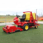 SMG SportChamp SC2D ride-on artificial turf cleaner parked on a synthetic field.