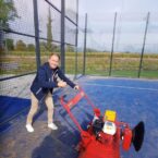 SMG TurfSoft TS3 turf cleaner in action on a blue synthetic sports court, with an operator demonstrating its key features.